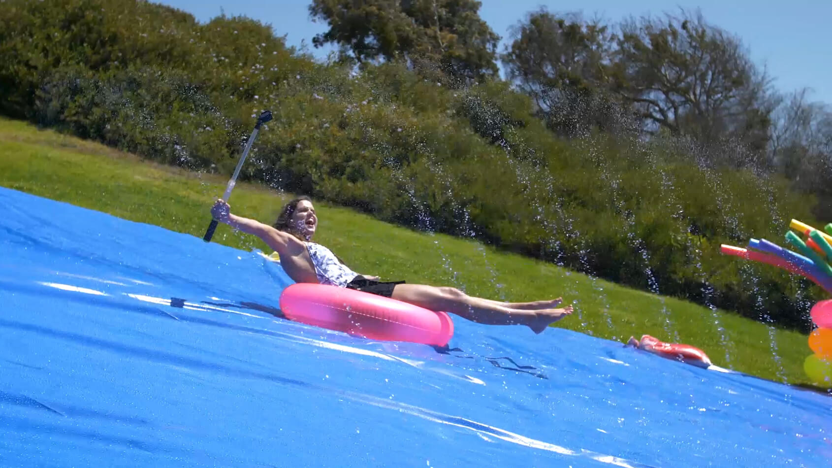 A female rides an inner tube down a water slide for Hollister Co.